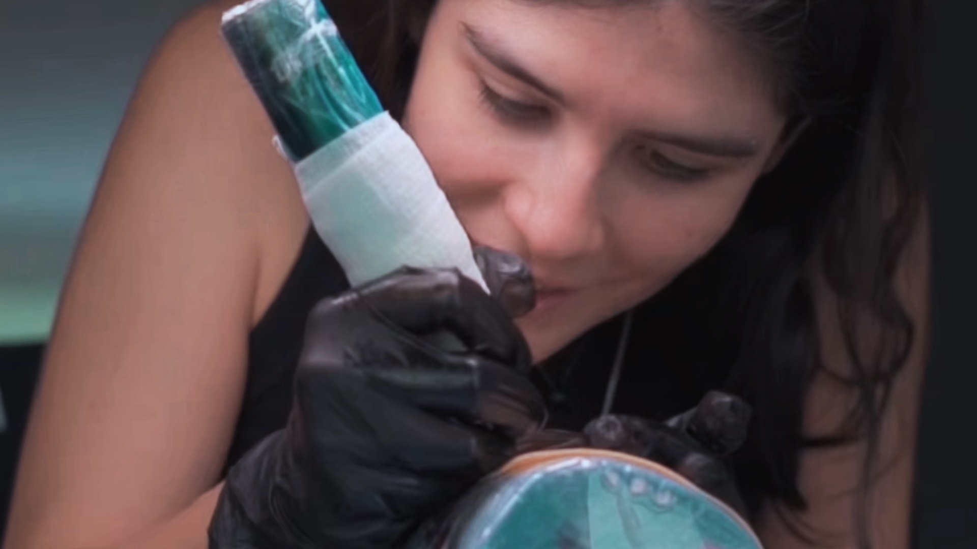 Alumna del Bootcamp practicando técnica de tatuaje sobre una superficie de entrenamiento